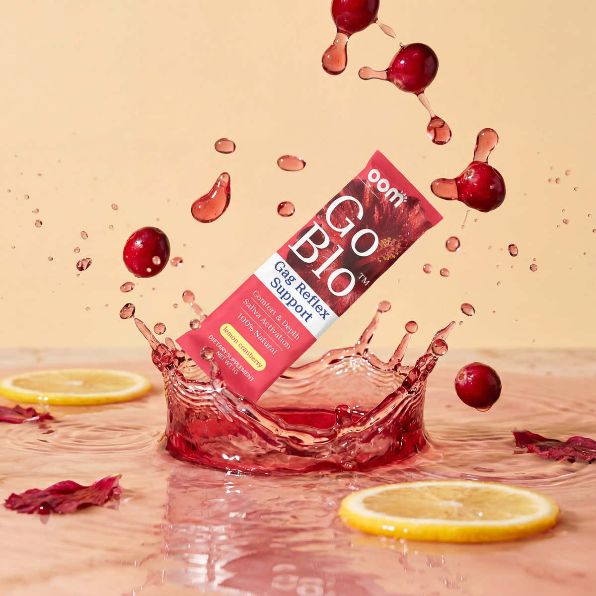 GoBlo stick pack splashing into cranberry-red water with lemon