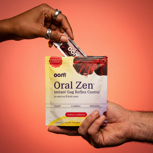 One black female hand with silver jewelry in the upper left pulls Oral Zen gag reflex control sachet from the pouch against a bold coral red background. A masculine male hand holds the multi-pouch from the bottom right of the screen. Edges of image have darker coral color.