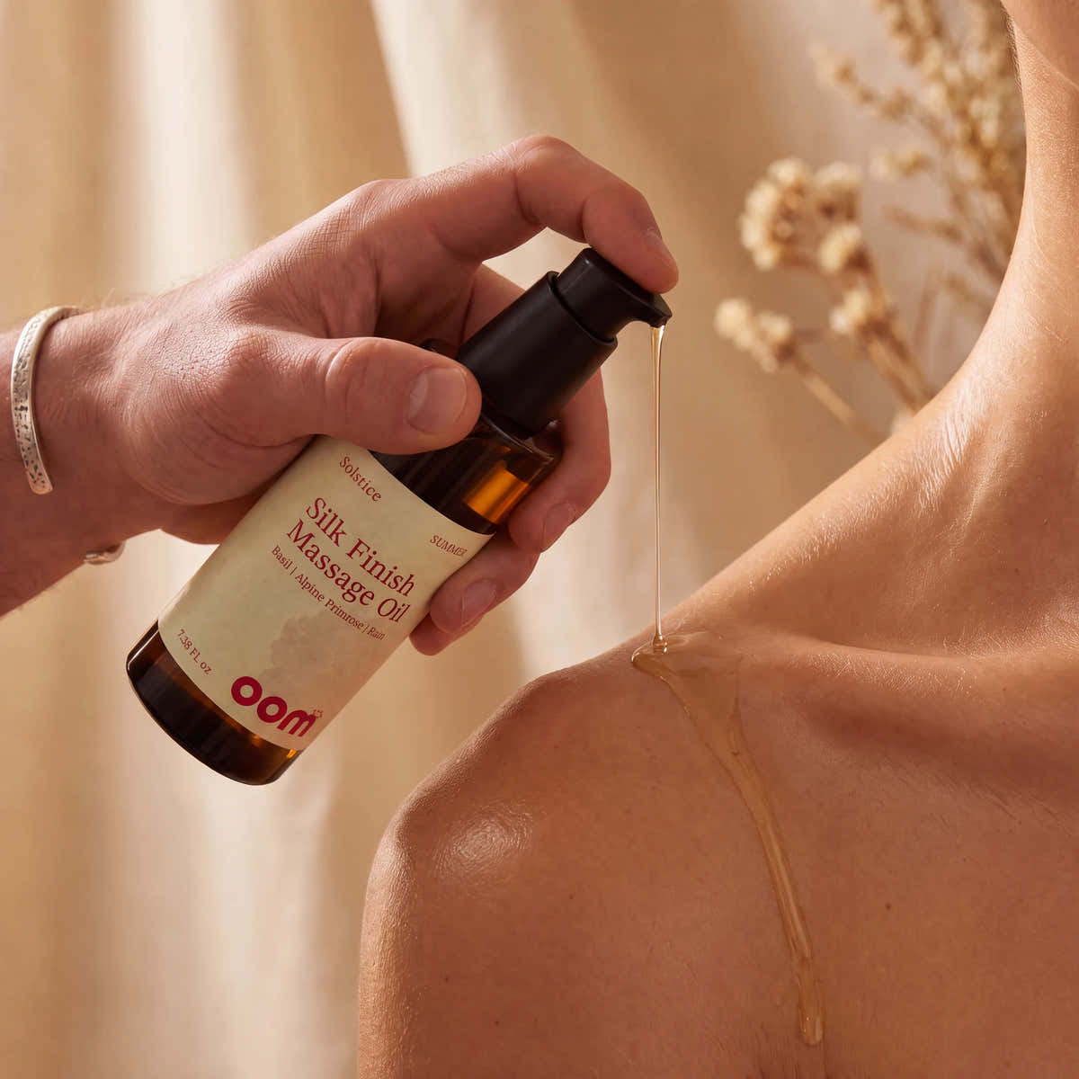 Solstice Summer Silk Finish Massage Oil being poured onto skin