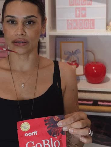 A woman swishes GoBlo, then smiles and holds up the pouch.